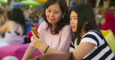 sahilde genç mutlu ve güzel Asya Çinli kız annesi ile selfie fotoğraf çekerken, bir 60s Olgun kadın, yaz tatilleri birlikte seyahat zevk