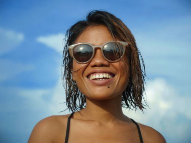 bikini ve güneş gözlüğü genç güzel ve seksi Asyalı kız baş ve omuzlar yaşam tarzı portre denizde mutlu serin gülümseyerek poz tropikal plajda tatil zevk