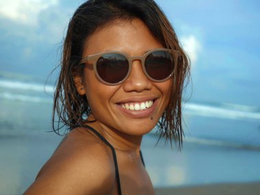 bikini ve güneş gözlüğü genç güzel ve seksi Asyalı kız baş ve omuzlar yaşam tarzı portre denizde mutlu serin gülümseyerek poz tropikal plajda tatil zevk