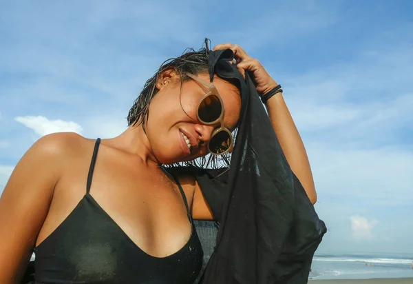 Hoved og skuldre livsstil portræt af ung smuk og sexet asiatisk pige i bikini og solbriller nyder ferie på tropisk strand poserende cool smilende glad ved havet - Stock-foto