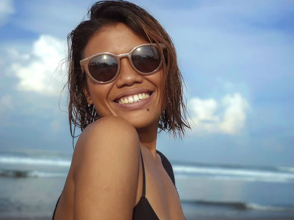 Cabeça e ombros estilo de vida retrato de jovem bela e sexy menina asiática em biquíni e óculos de sol desfrutando de férias na praia tropical posando fresco sorrindo feliz no mar — Fotografia de Stock