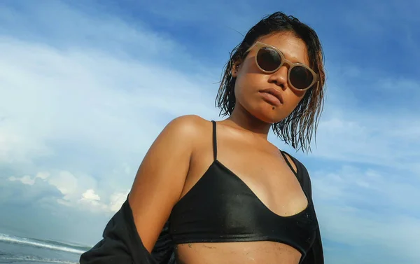 Cabeça e ombros estilo de vida retrato de jovem bela e sexy menina asiática em biquíni e óculos de sol desfrutando de férias na praia tropical posando fresco e confiante no mar — Fotografia de Stock