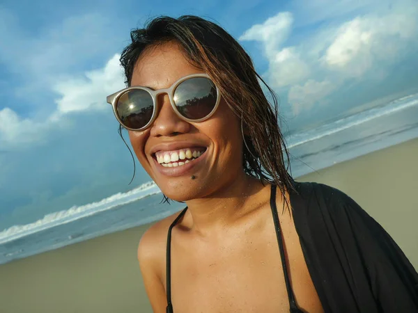 Cabeça e ombros estilo de vida retrato de jovem bela e sexy menina asiática em biquíni e óculos de sol desfrutando de férias na praia tropical posando fresco sorrindo feliz no mar — Fotografia de Stock