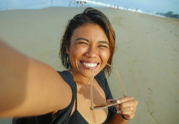 Jovem feliz e atraente asiático exótico mulher na praia tomando selfie retrato com celular sorrindo alegre desfrutando férias viagem na bela ilha tropical — Fotografia de Stock