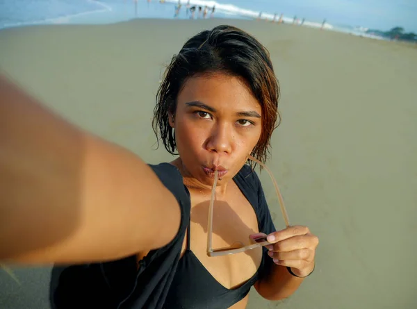 Jovem feliz e atraente asiático exótico mulher na praia tomando selfie retrato com celular sorrindo alegre desfrutando férias viagem na bela ilha tropical — Fotografia de Stock