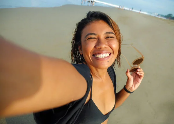 Jovem feliz e atraente asiático exótico mulher na praia tomando selfie retrato com celular sorrindo alegre desfrutando férias viagem na bela ilha tropical — Fotografia de Stock