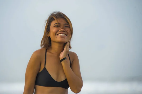 Юна екзотична і чарівна азіатська дівчина в бікіні посміхається спокійно і безтурботно насолоджуючись святами на тропічному пляжі щасливі і веселі веселощі в морі — стокове фото