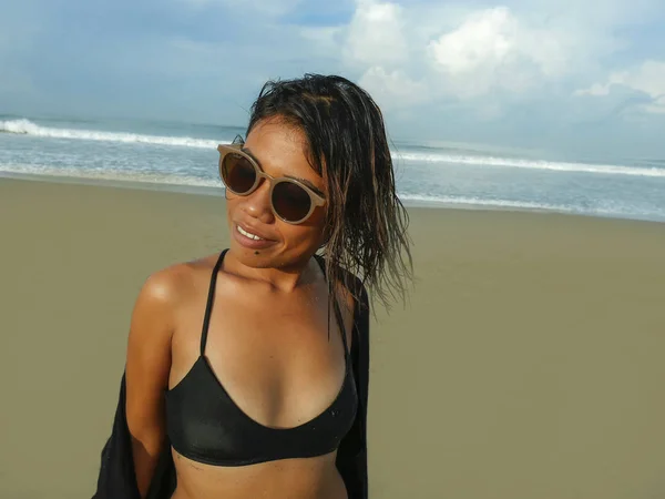 年轻美丽和性感的亚洲女孩在比基尼和太阳镜享受假期在热带海滩的生活肖像在海边摆出凉爽和自信 — 图库照片