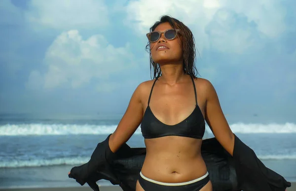 年轻美丽和性感的亚洲女孩在比基尼和太阳镜享受假期在热带海滩的生活肖像在海边摆出凉爽和自信 — 图库照片