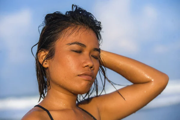 身穿比基尼、头发湿透的年轻漂亮性感的亚洲女孩在热带海滩度假时，带着一种异国情调的海市蜃楼般的放松与快乐 — 图库照片