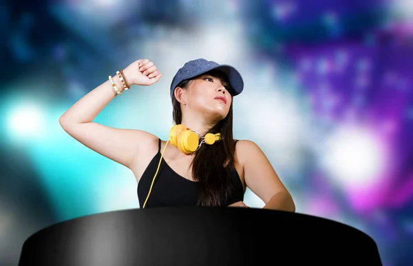 Junge attraktive und glückliche asiatische japanische dj Frau Remixing Techno-Musik mit DJ-Ausrüstung und Kopfhörer im Nachtclub mit Lichtern Hintergrund in clubbing Spaß in der Nacht — Stockfoto