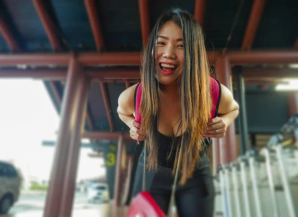 Young happy and attractive Asian Chinese backpacker woman smiling at airport arrival or departure feeling excited in holidays tourist trip and student travel — ストック写真