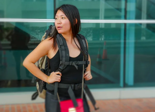 Young happy and attractive Asian Japanese backpacker woman smiling excited at airport arrival or departure carrying big backpack in holidays tourist trip — 스톡 사진
