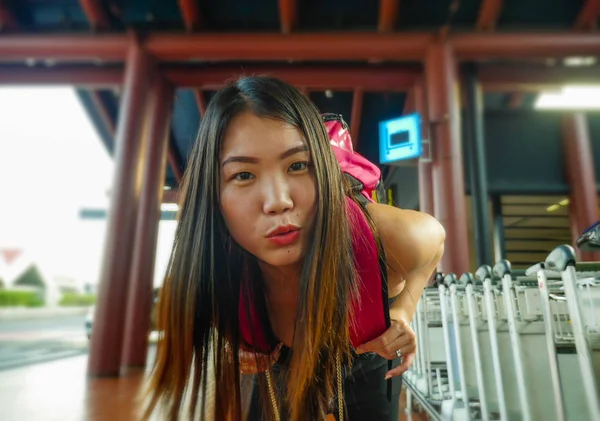 Young happy and attractive Asian Chinese backpacker woman smiling at airport arrival or departure feeling excited in holidays tourist trip and student travel — ストック写真