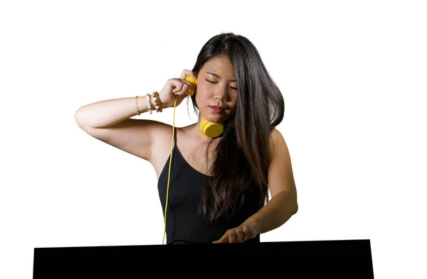 Nuori kaunis ja houkutteleva aasialainen kiinalainen DJ nainen remixing musiikkia yökerhossa yllään kuulokkeet klubi puolue ja DJY elämäntapa käsite eristetty tausta — kuvapankkivalokuva