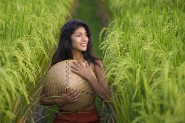 Genç ve güzel İspanyol kadın geleneksel Asyalı çiftçi şapkasıyla gülüyor Asya 'da yeşil pirinç tarlasında izole edilmiş seksi poz veriyor.