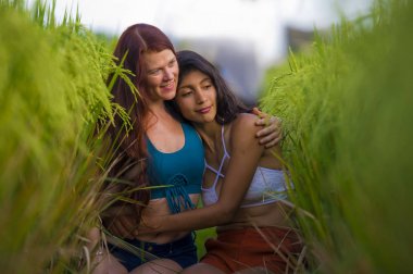 latin kız ve onun çekici Kafkas kız arkadaşı her iki kadın yaz tatili zevk birlikte pirinç alanında eğlenmek mutlu mutlu mutlu çeşitlilik dostluk ve sevgi rahat gülümseyerek