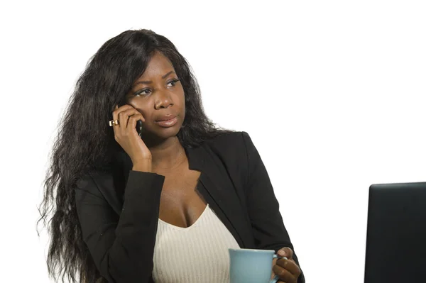 Joven hermosa y ocupada afroamericana negra empresaria hablando por teléfono móvil en la oficina trabajando con computadora portátil bebiendo café en el éxito de trabajo de la mujer —  Fotos de Stock