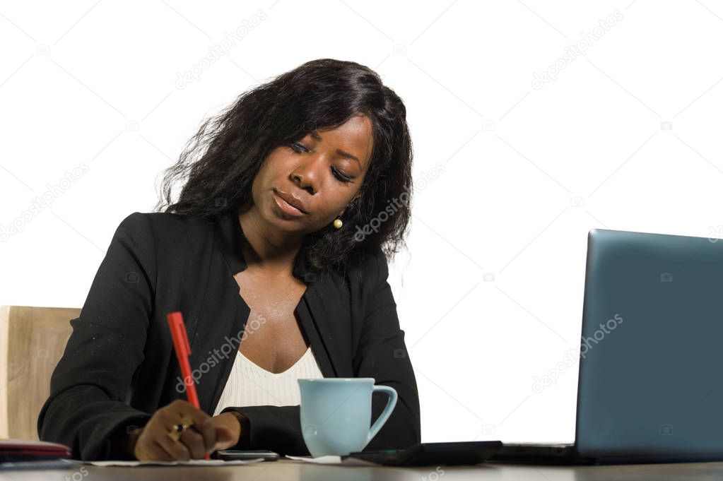 young beautiful and busy black afro American businesswoman writing notes on desk working with laptop computer at company office in woman job success