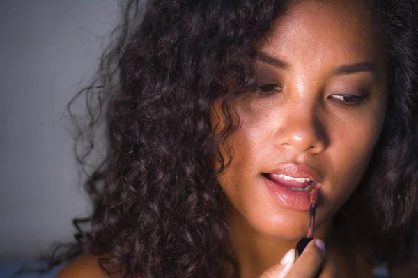 Portrait of young beautiful and natural mixed ethnicity Caucasian and afro American woman using makeup on her lips at home in fashion and beauty concept — Stock Photo, Image