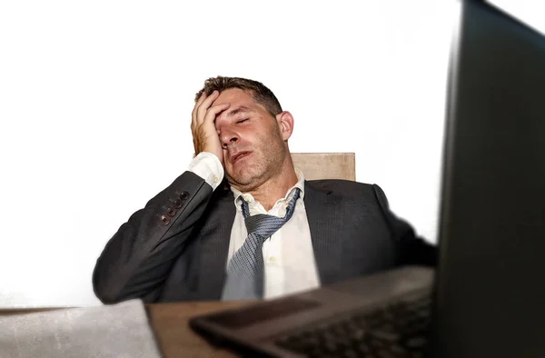 Jovem frustrado e estressado empresário de terno e gravata trabalhando sobrecarregado no escritório laptop mesa de computador desesperada e preocupada causa de estresse no trabalho — Fotografia de Stock