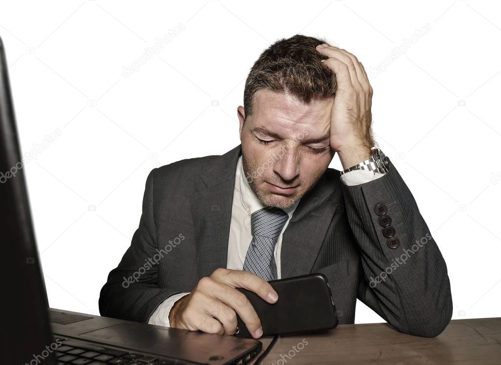 young frustrated and stressed businessman in suit and tie working overwhelmed at office laptop computer desk desperate and worried cause of work stress