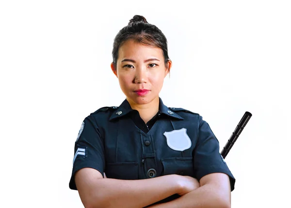 Młody atrakcyjny i buntowniczy azjatycki chiński policjant w mundurze trzymając kij obronny poważne izolowane na białym tle w okupacji organów ścigania — Zdjęcie stockowe