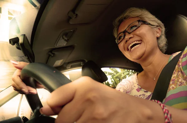 Estilo de vida Retrato de verão de meia-idade feliz e atraente elegante mulher indonésia asiática dirigindo carro sorrindo alegre e livre em um dia ensolarado — Fotografia de Stock