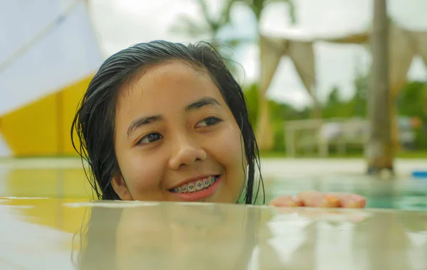 На відкритому повітрі портрет молодий красивий і солодкий азіатських Індонезійська підліток дівчина купання в тропічному басейні курорту посміхаючись щасливі і веселий насолоджуючись розслабленої свята поїздка — стокове фото