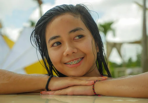 Al aire libre retrato de joven hermosa y dulce asiática indonesia adolescente nadando en tropical resort piscina sonriendo feliz y alegre disfrutando relajado vacaciones viaje —  Fotos de Stock