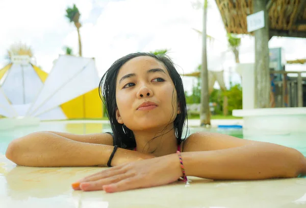 Al aire libre retrato de joven hermosa y dulce asiática indonesia adolescente nadando en tropical resort piscina sonriendo feliz y alegre disfrutando relajado vacaciones viaje —  Fotos de Stock