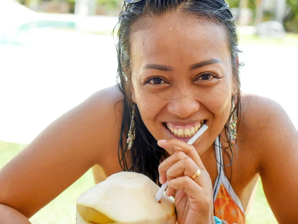 30 대 또는 40 대 행복 하 고 매력적인 아시아 인도네시아 여자에 비키니 마시는 코코넛 물 열대 리조트 수영장에서 쾌활 한 미소의 라이프 스타일 자연 초상화 — 스톡 사진