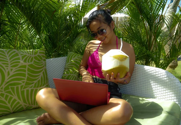 Estilo de vida al aire libre retrato de los jóvenes felices y atractivos Asiática adolescente indonesia en bikini en red con ordenador portátil en la cama de jardín del complejo tropical —  Fotos de Stock