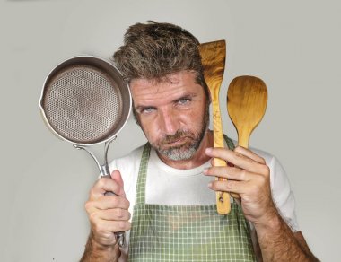 apron tutan kaşık ve tava da çekici mutsuz ve ezilmiş ev aşçı adam üzgün ve iç iş ve izole arka plan üzerinde pişirme görevi tembel duygu