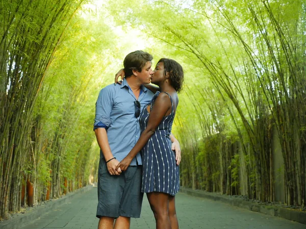Молода приваблива мішана етнічна пара цілується на вулиці з привабливою чорношкірою афро-американкою і красивим кавказьким бойфрендом або чоловіком у романтичному блозі. — стокове фото