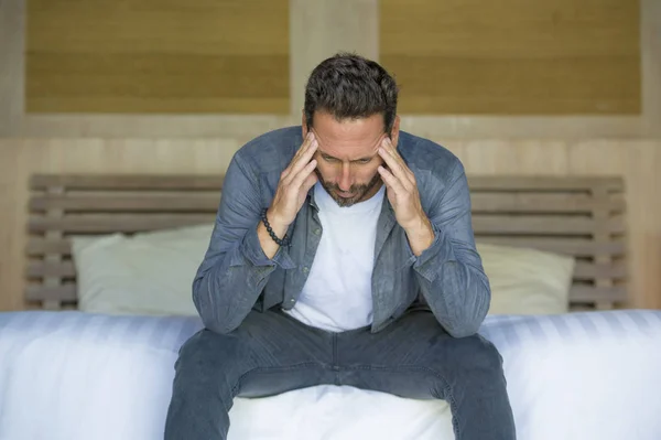 Retrato de jovem atraente oprimido e deprimido homem sentado na cama preocupado e frustrado sofrendo crise depressiva demitido do trabalho ou divórcio problema — Fotografia de Stock