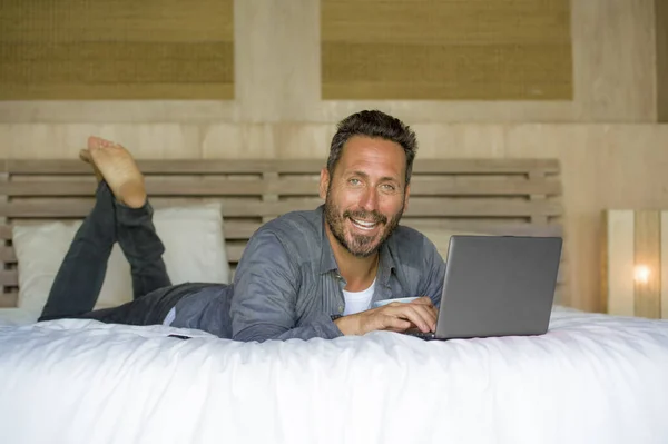 Evde genç çekici ve mutlu adam iç portre dizüstü bilgisayar serbest ağ iş başarısı neşeli gülümseyerek yatakta rahat çalışma — Stok fotoğraf