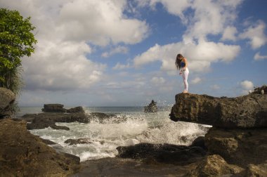 oung çekici ve konsantre kadın sağlıklı doğal yaşam tarzı güzel plaj kaya uçurumda mutlu ve rahat gülümseyerek yoga meditasyon egzersiz icra