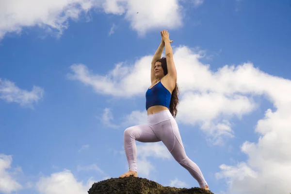 Young attractive and concentrated woman practicing acroyoga balance exercise and yoga flexibility and meditation at beautiful beach rock cliff in healthy lifestyle — Stock Photo, Image