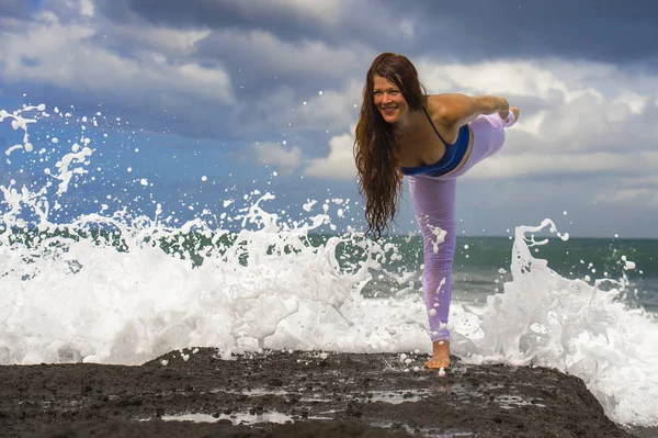 Junge attraktive und konzentrierte Frau praktiziert Acroyoga Gleichgewichtsübungen und Yoga Flexibilität und Meditation auf dem Meer an schönen tropischen Strandfelsen — Stockfoto