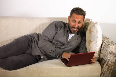 evde dizüstü bilgisayar kullanarak çalışan genç yakışıklı ve başarılı serbest çalışan adam doğal yaşam tarzı portre yaşayan kanepe ağ rahat yalan