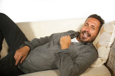 sakallı genç çekici ve mutlu beyaz adam yaşam tarzı ev portresi rahat ve rahat oturma odası kanepe de rahat ve rahat yalan ve neşeli gülümseyen