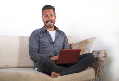 genç yakışıklı ve başarılı kendini istihdam adam evde dizüstü bilgisayar kullanarak çalışan yaşam tarzı portre neşeli yaşayan kanepe ağ rahat oturan