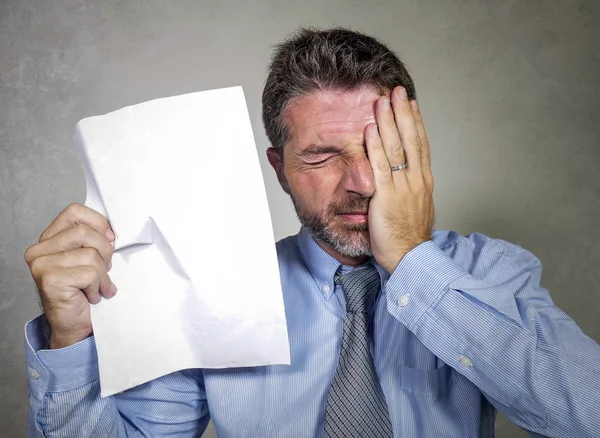 Gestrest en overweldigd 30s tot 40s zakenman in shirt en stropdas gestrest en overweldigd met papier in zijn hand gevoel boos en gefrustreerd — Stockfoto