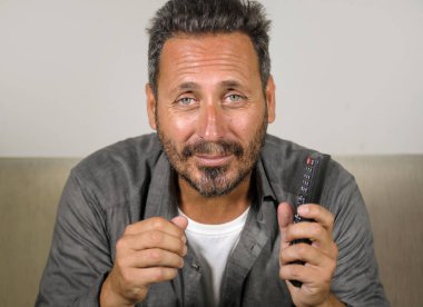 30'larında ya da 40'lı yaşlarında heyecanlı ve çekici bir adam evde spor maçı veya gerilim filmi izlerken eğleniyor televizyon oturma odasında ki kanepede otururken gergin hissediyorum