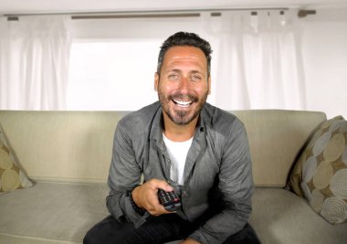 yakışıklı ve mutlu 30'lu ya da 40'lı yaşlar beyaz adam evde komik televizyon programı izlerken neşeli eğlenceli oturma rahat ve serin oturma oturma kanepe