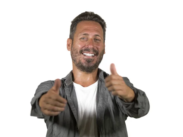 Portrait of young happy and attractive man hugging himself smiling positive and charming giving thumb up in okay and agreement hand sign isolated on white — Stock Photo, Image
