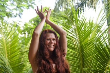 sağlıklı yaşam tarzı ve uyum inanılmaz tropikal orman arka plan yoga meditasyon egzersiz yapıyor güzel uzun kırmızı saçlı genç mutlu ve çekici kadın doğal portre