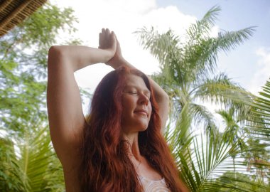 sağlıklı yaşam tarzı ve uyum inanılmaz tropikal orman arka plan yoga meditasyon egzersiz yapıyor güzel uzun kırmızı saçlı genç mutlu ve çekici kadın doğal portre