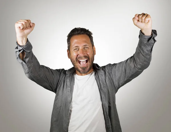 Retrato de joven hombre caucásico feliz y atractivo gesto con el puño levantando los brazos en señal de victoria y éxito sonriente alegre excitado sentimiento fuerte emoción — Foto de Stock